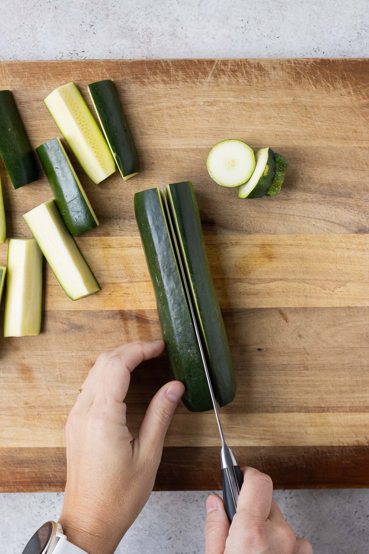 Zucchini is sliced on a cutting board.