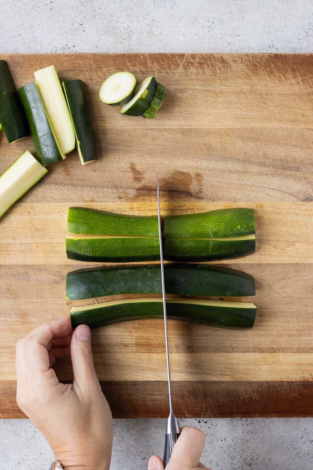 Zucchini is sliced on a cutting board.