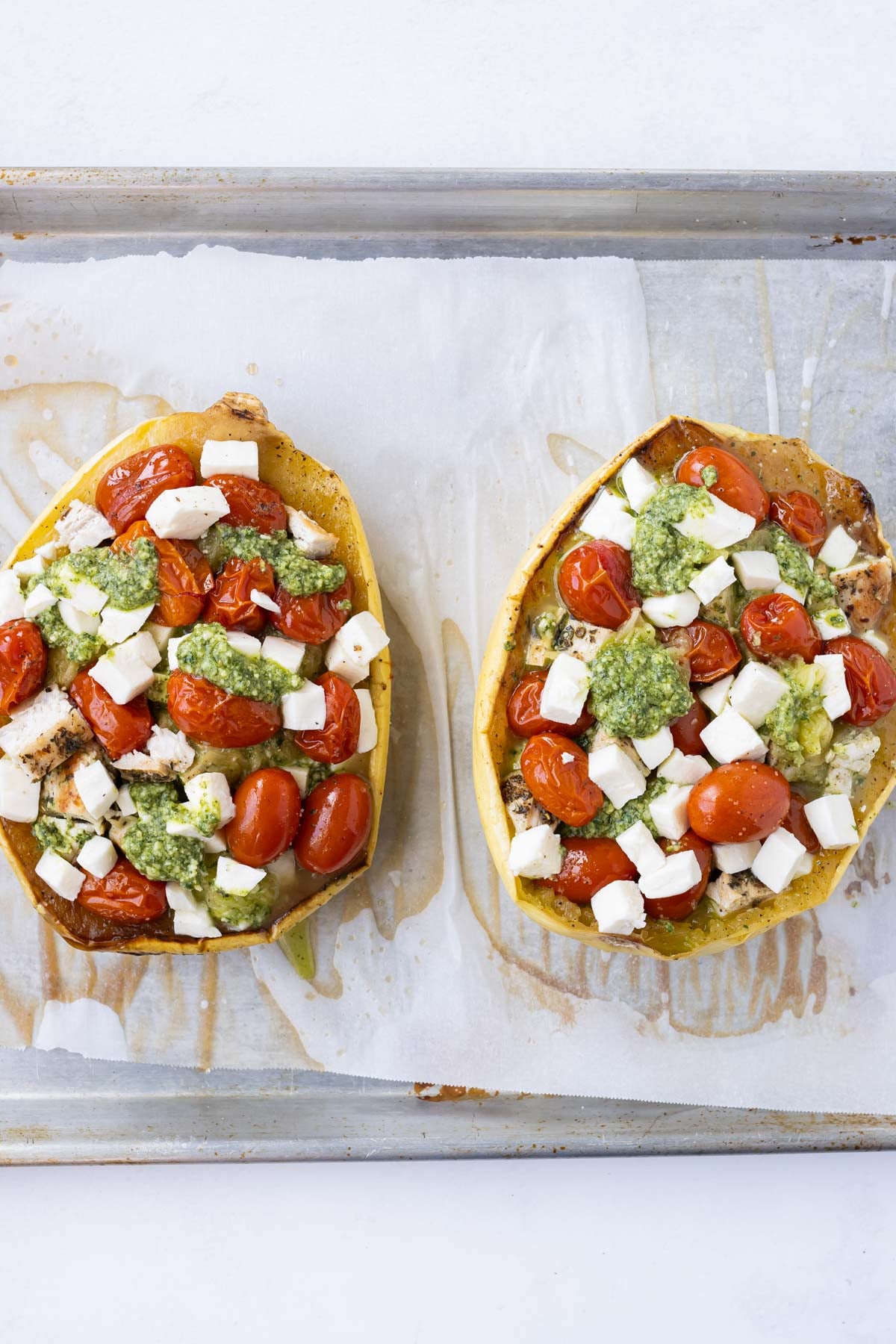 Chicken, tomatoes, and pesto are added to the spaghetti squash.