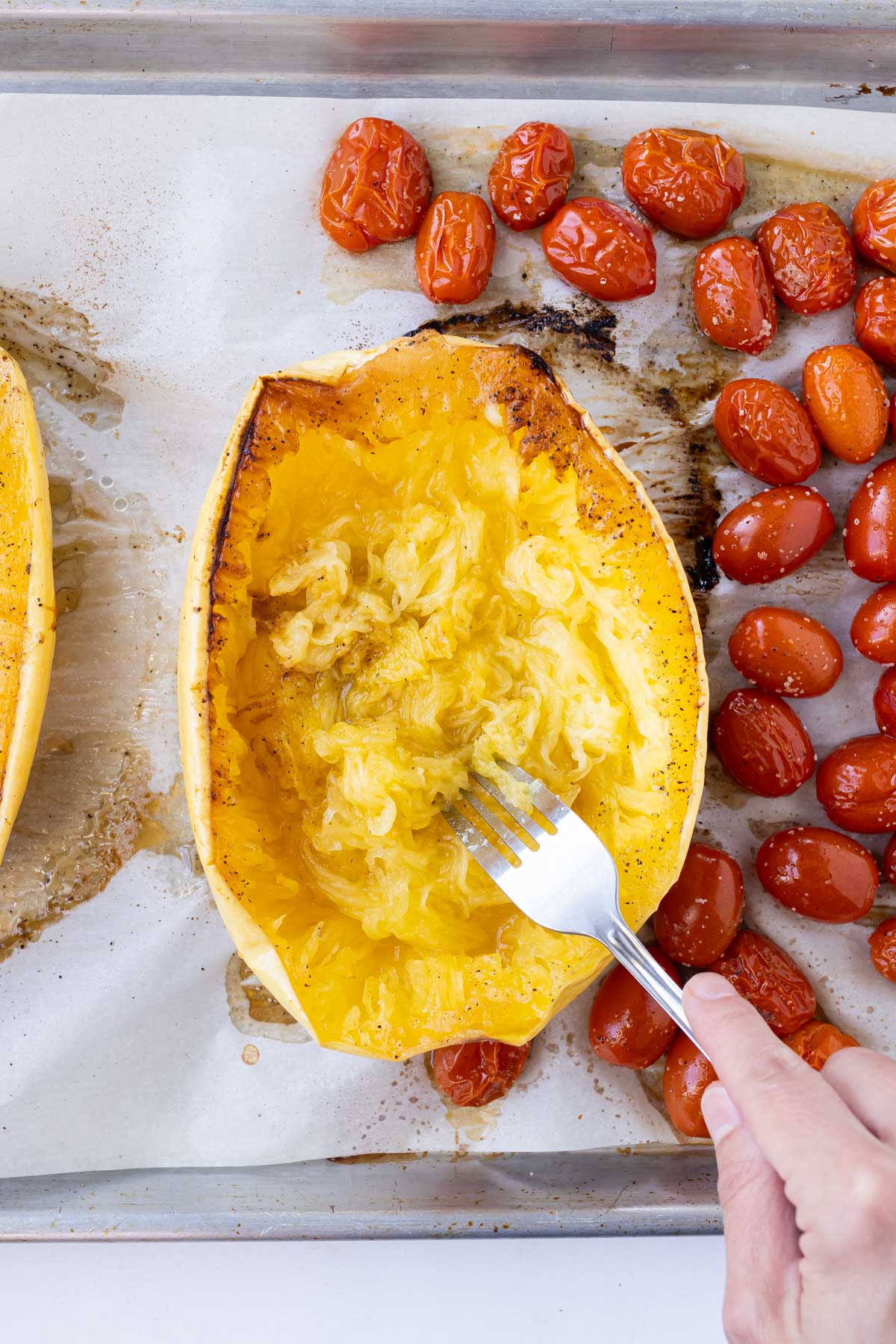 A fork pulls the insides of the spaghetti squash.