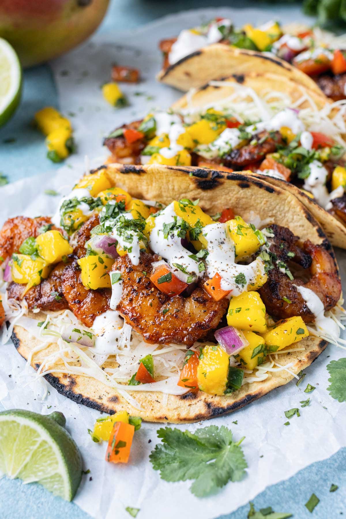 Shrimp tacos with mango salsa are spread on a tray for dinner.