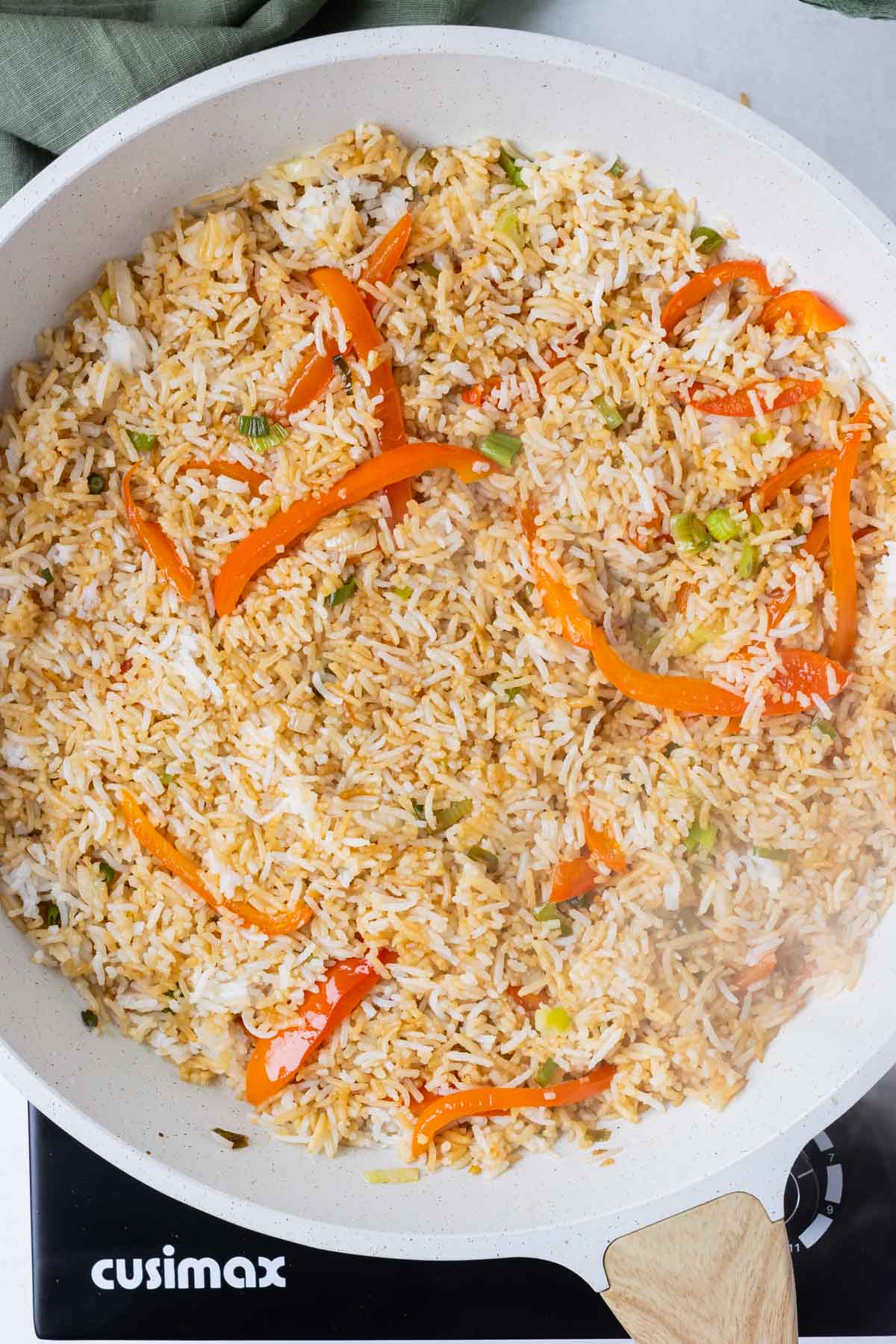 Cooked rice is added to the skillet to make fried rice.