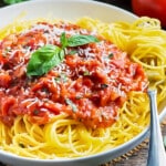 A bowl of spaghetti is served with a homemade pomodoro sauce with basil.