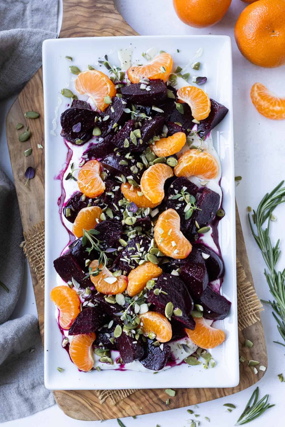 Honey roasted beets and orange segments are served on top of a whipped herb goat cheese for an easy holiday side dish recipe.
