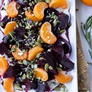 A white platter is full of Roasted Beets with oranges and whipped goat cheese for an easy holiday side dish.