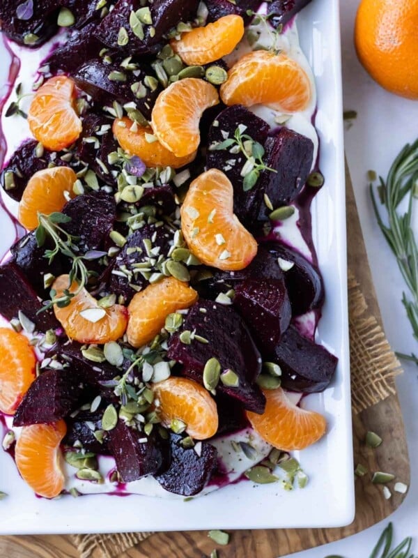 A white platter is full of Roasted Beets with oranges and whipped goat cheese for an easy holiday side dish.