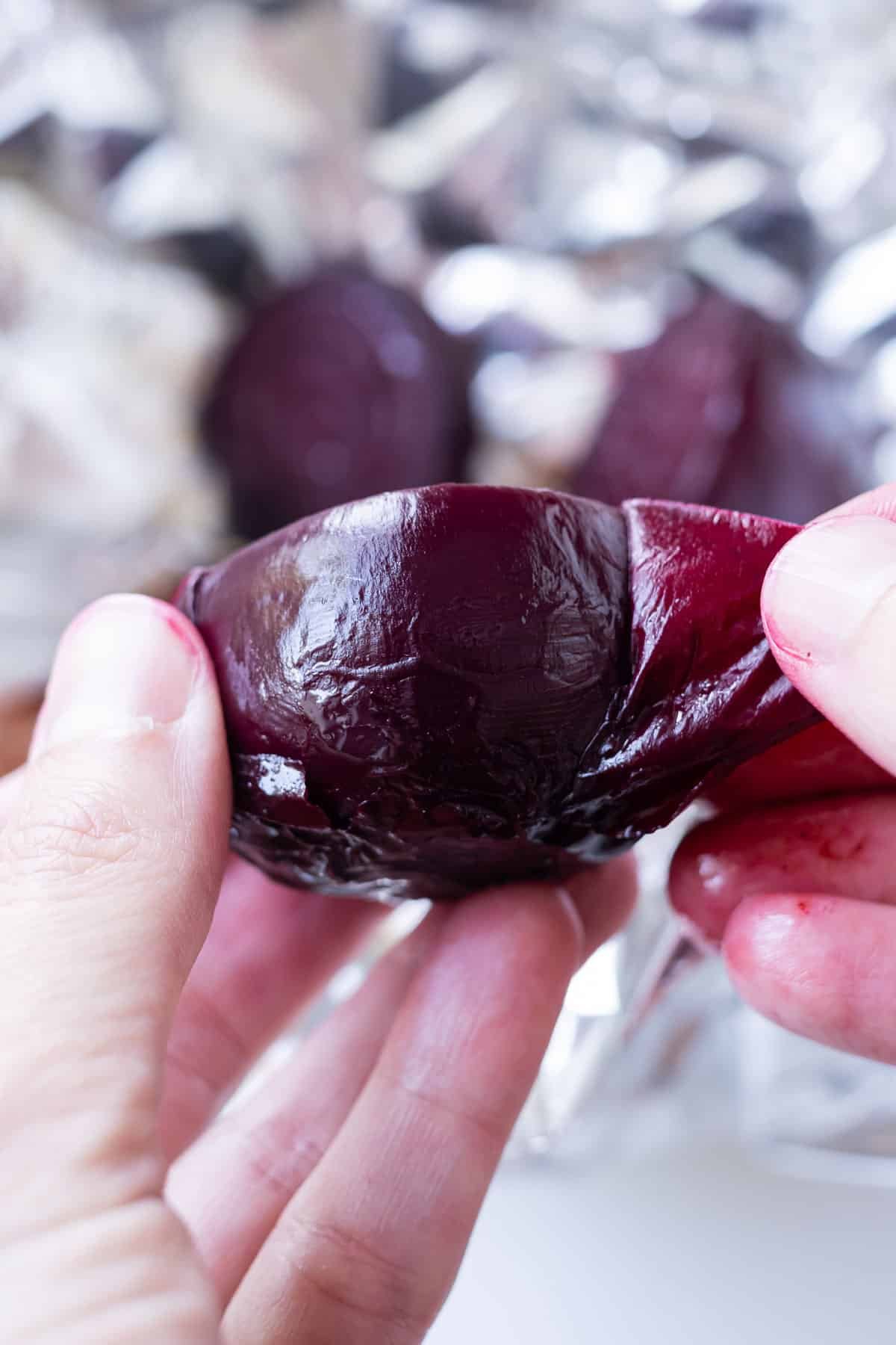 The outer skin is peeled from a roasted beet.
