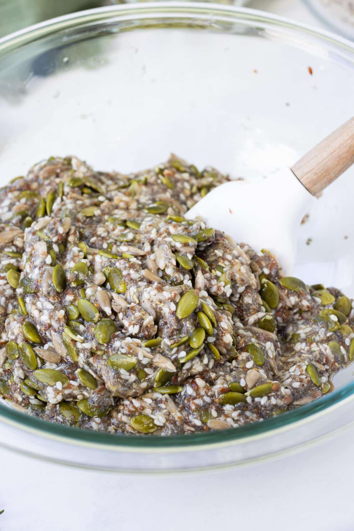 A spatula stirs to combine the cracker base.