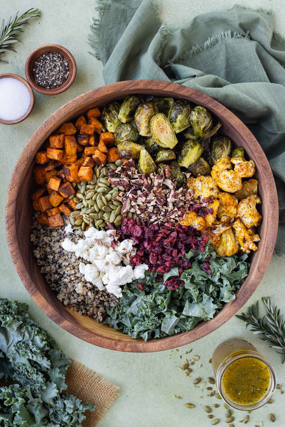All of the ingredients for this warm fall quinoa salad are combined in a wooden bowl.