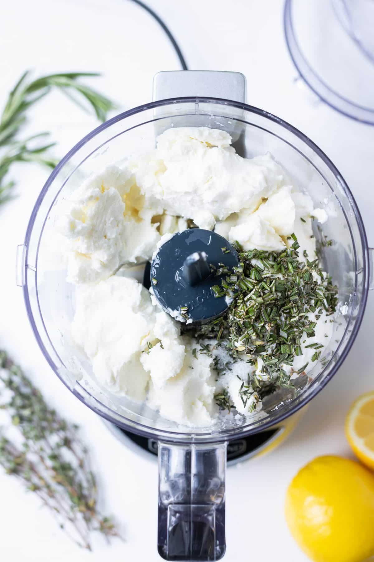The goat cheese ingredients are added to a food processor.