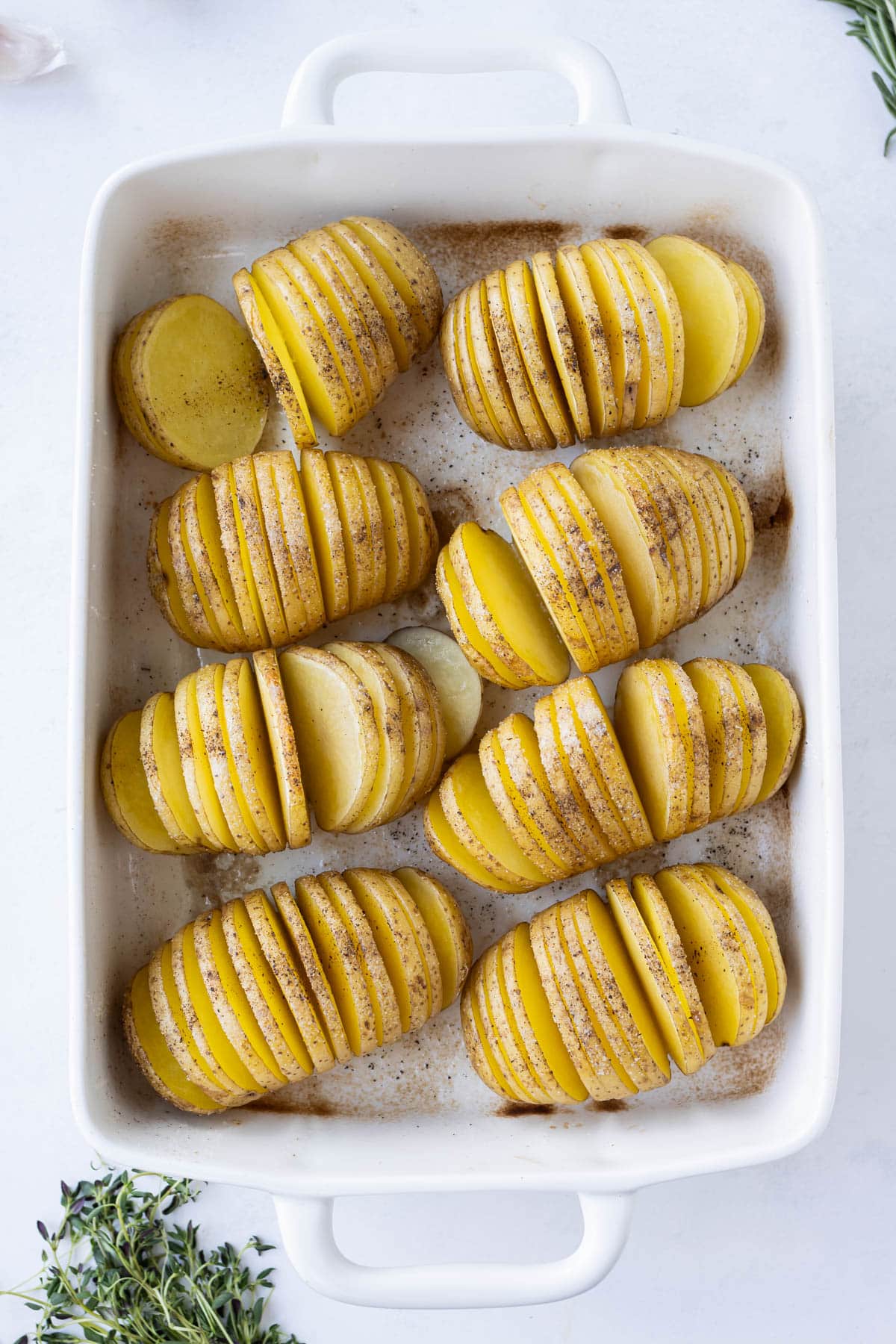 Sliced potatoes are set in a baking dish.