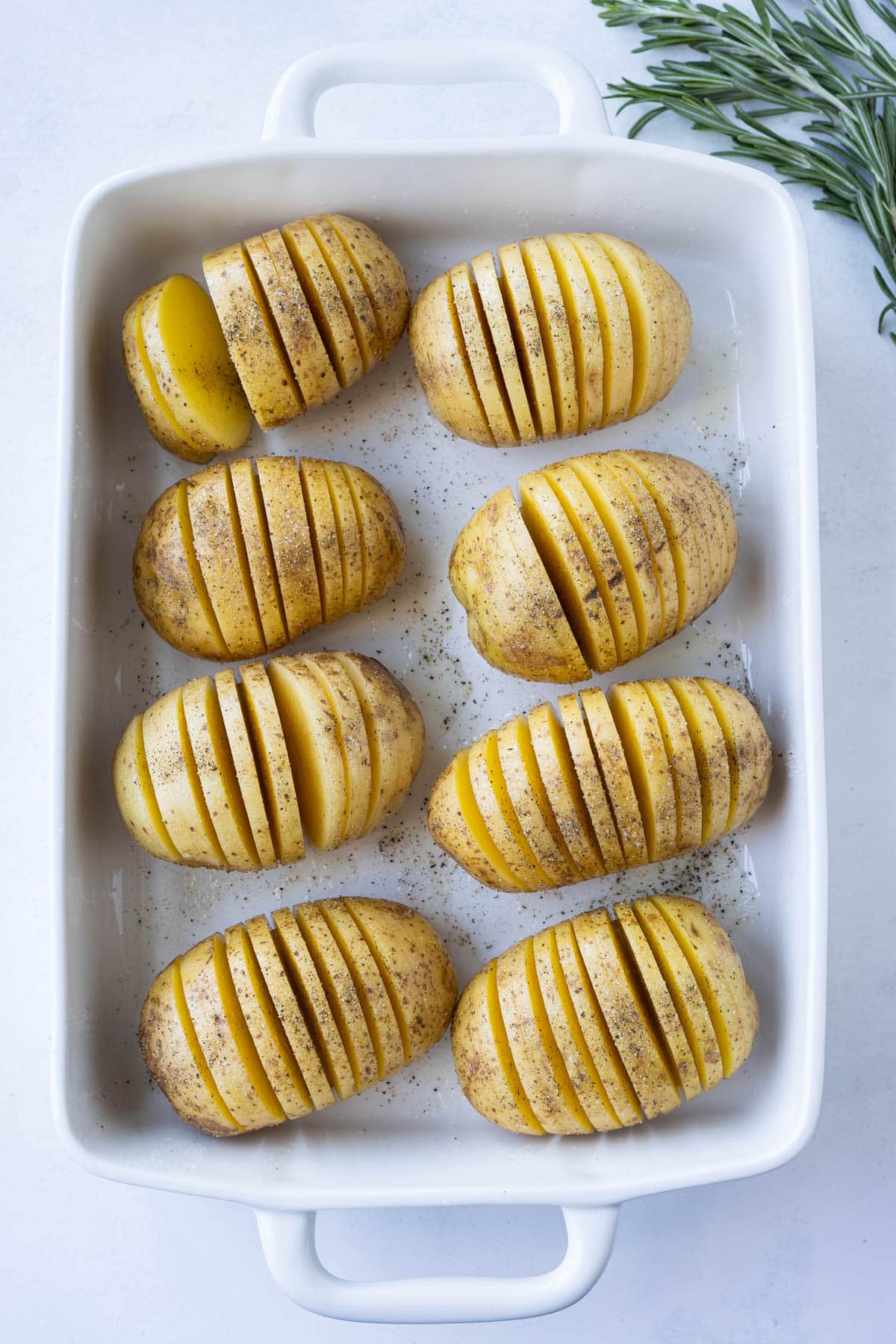 Sliced potatoes are set in a baking dish.