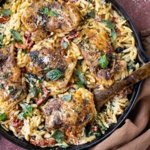 A spoon scoops up a serving of some Marry Me Chicken Orzo Pasta Bake as a one-pot dinner.