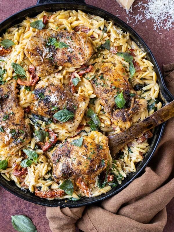 A spoon scoops up a serving of some Marry Me Chicken Orzo Pasta Bake as a one-pot dinner.