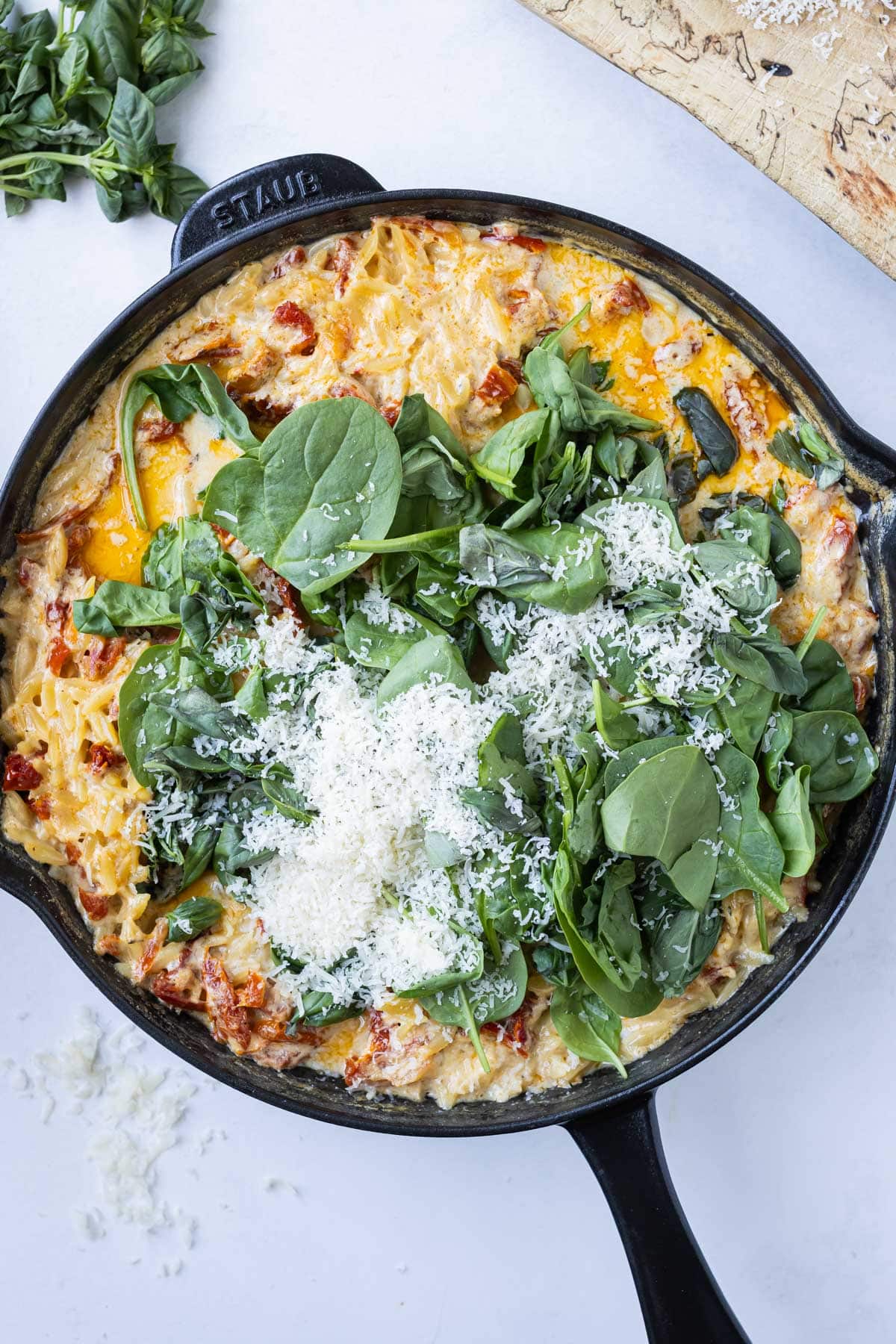 Basil, spinach, and Parmesan are stirred into the creamy base.