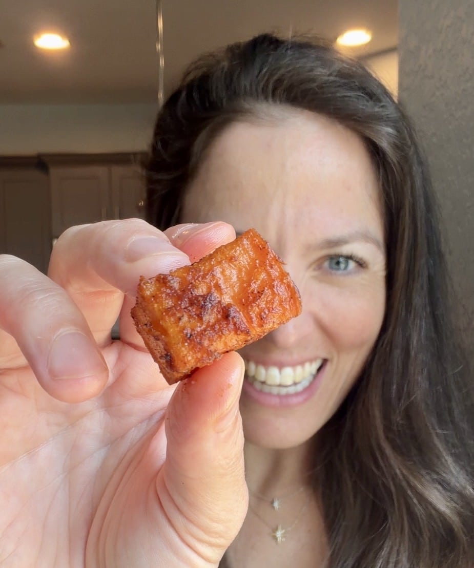 London Lea holding a roasted sweet potato cube.