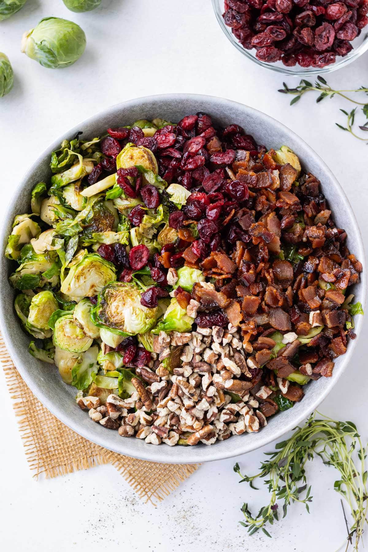 Cooked Brussels sprouts are tossed with pecans, bacon, and dried cranberries.