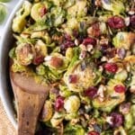 A salad bowl full of Maple Bacon Shredded Brussels Sprouts is served with a spoon for dinner.
