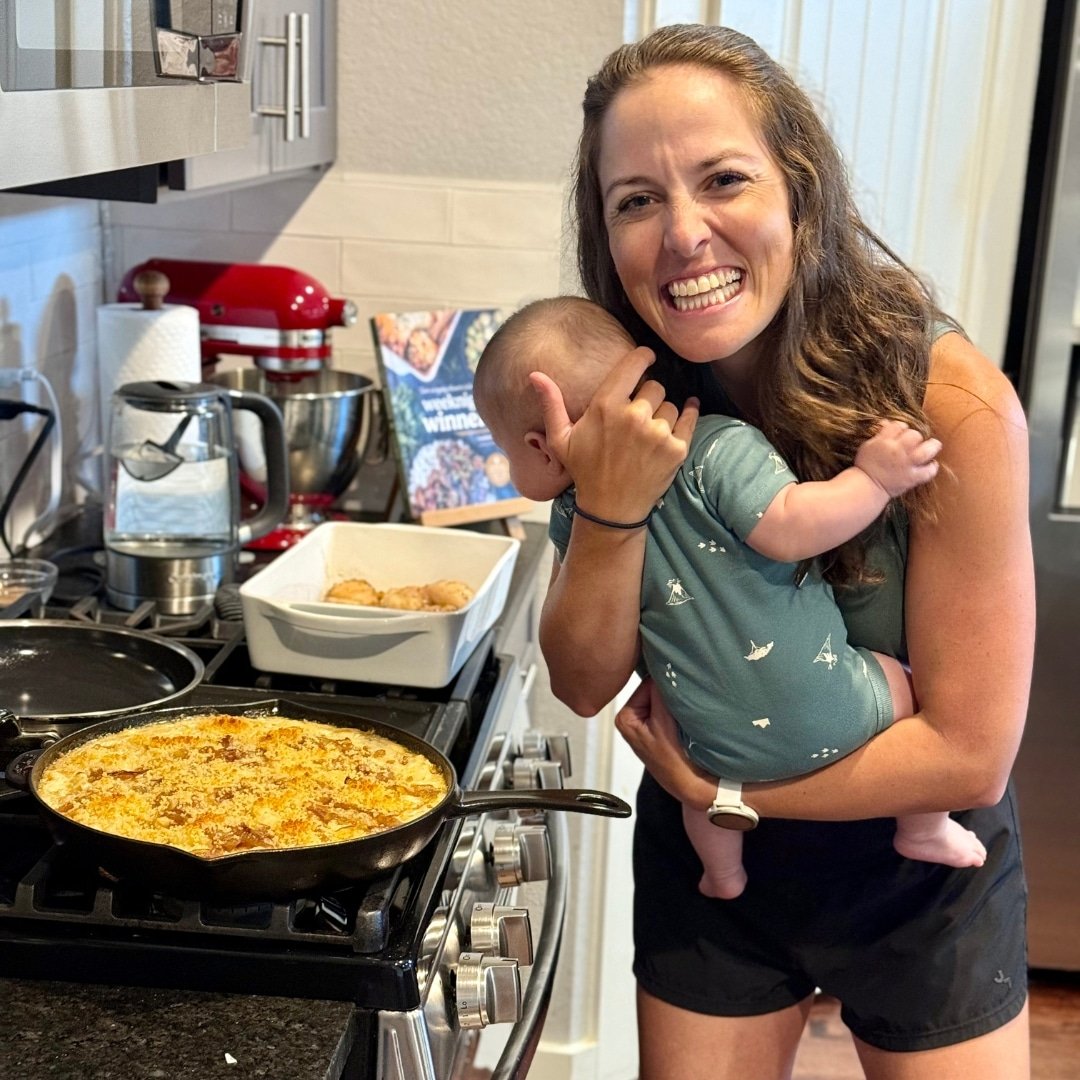 London and Fielder Lea standing next to a skillet full of French Onion Mac and Cheese on the stovetop.