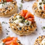 Salmon Cream Puffs with an everything bagel seasoning, capers, and dill are on a platter for serving at a party.