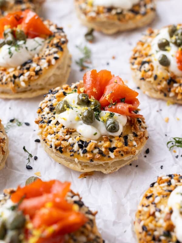 Salmon Cream Puffs with an everything bagel seasoning, capers, and dill are on a platter for serving at a party.