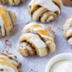 Mini Cinnamon Roll Croissants made from puff pastry with an icing glaze are served on a holiday appetizer tray.
