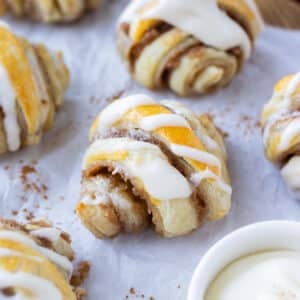 Mini Cinnamon Roll Croissants made from puff pastry with an icing glaze are served on a holiday appetizer tray.