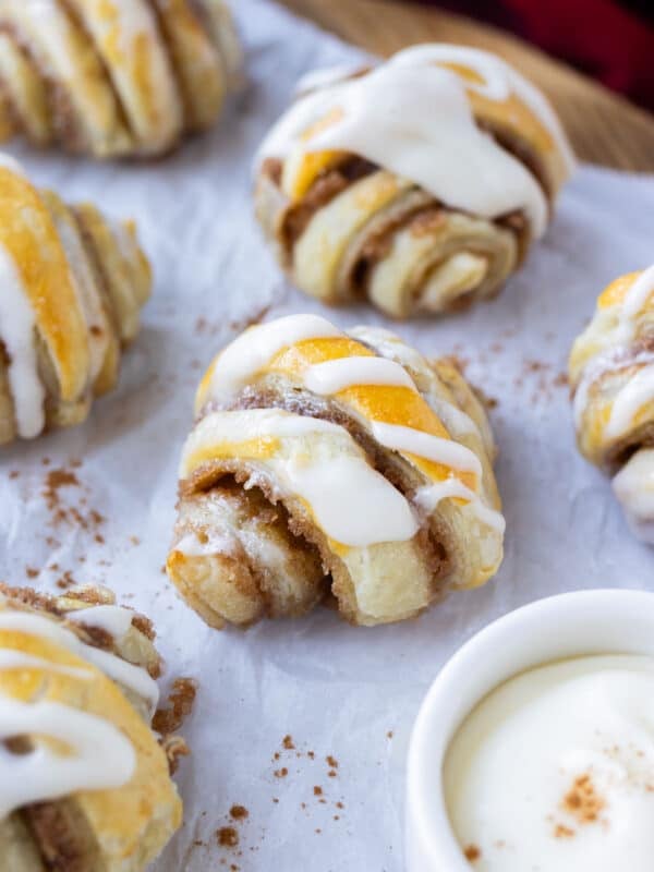 Mini Cinnamon Roll Croissants made from puff pastry with an icing glaze are served on a holiday appetizer tray.