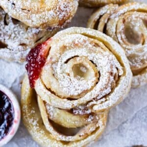 Monte Cristo Puff Pastry Pinwheels are stacked on a serving tray as appetizers for a holiday party.