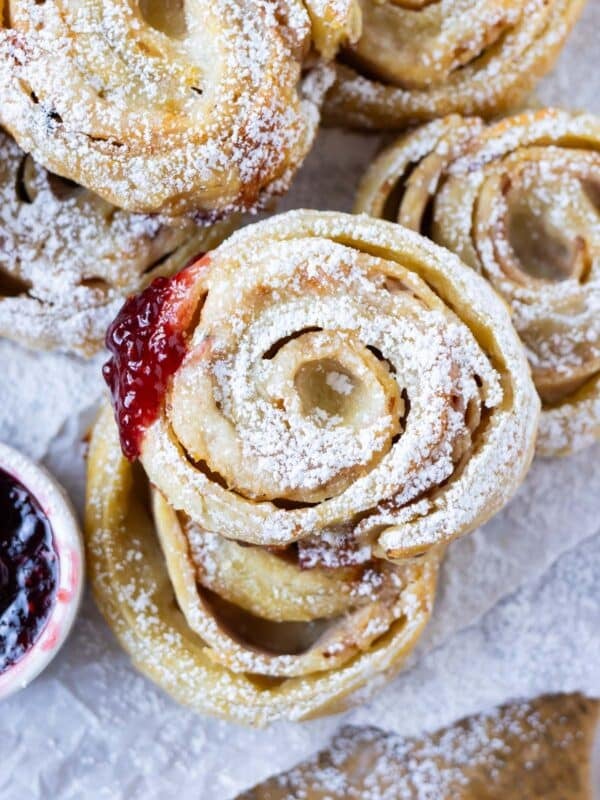 Monte Cristo Puff Pastry Pinwheels are stacked on a serving tray as appetizers for a holiday party.