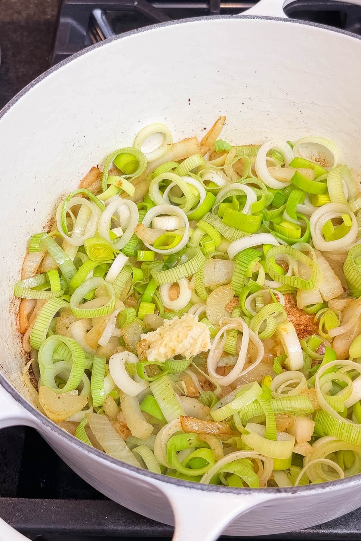 Leeks, fennel, and garlic cooking in a Dutch oven.