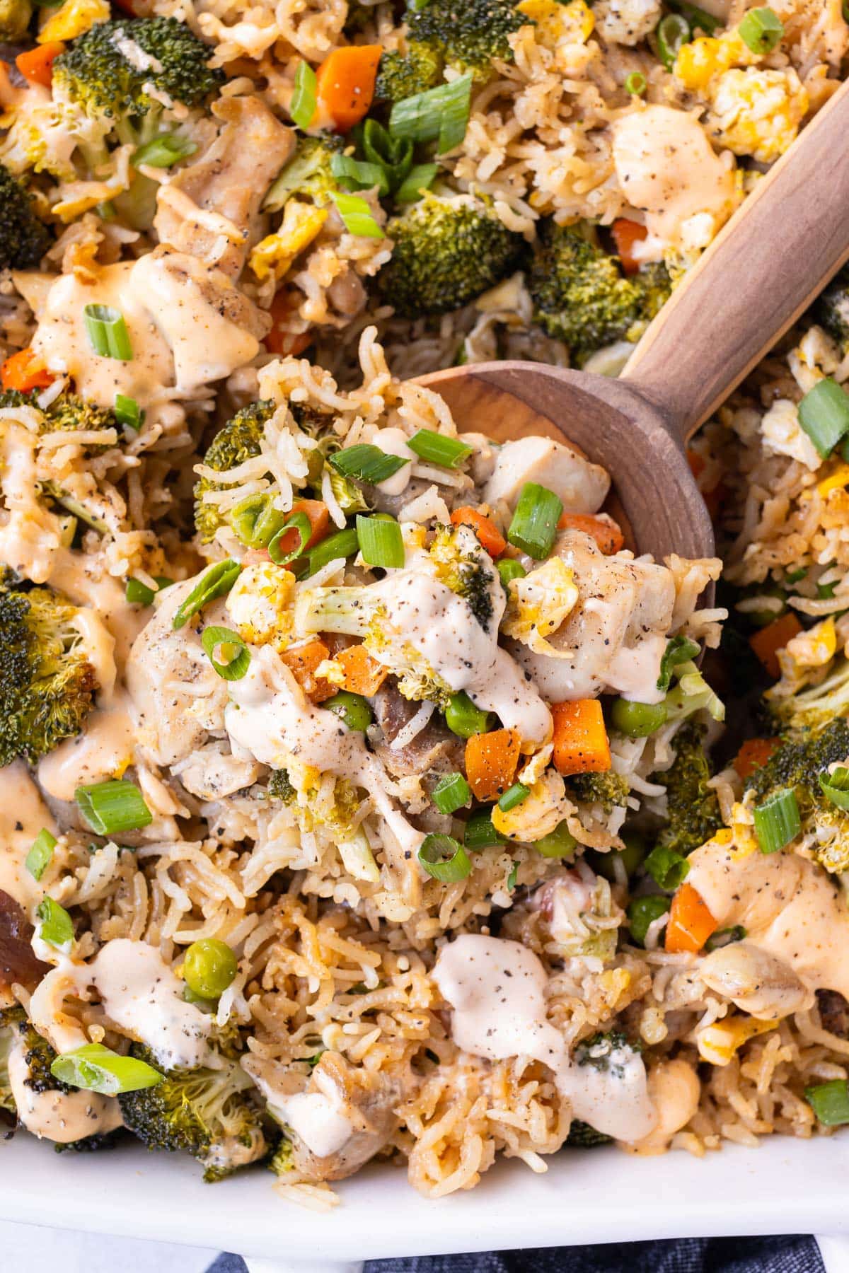 A spoon is scooping up a chicken fried rice dump and bake from a baking dish.