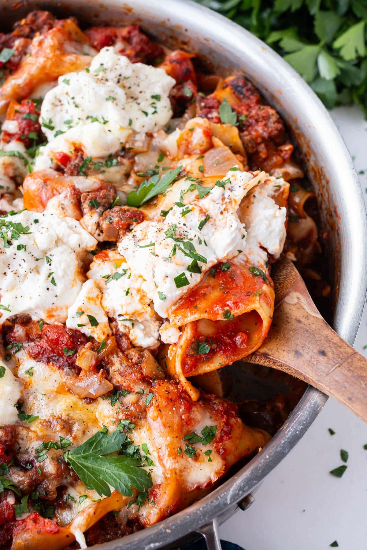 A spoon scoops up a big serving of a lazy lasagna from a pot.