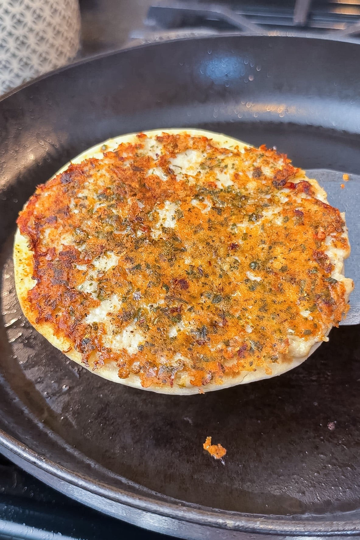 Golden crispy parmesan-crusted chicken taco cooking in a cast iron skillet