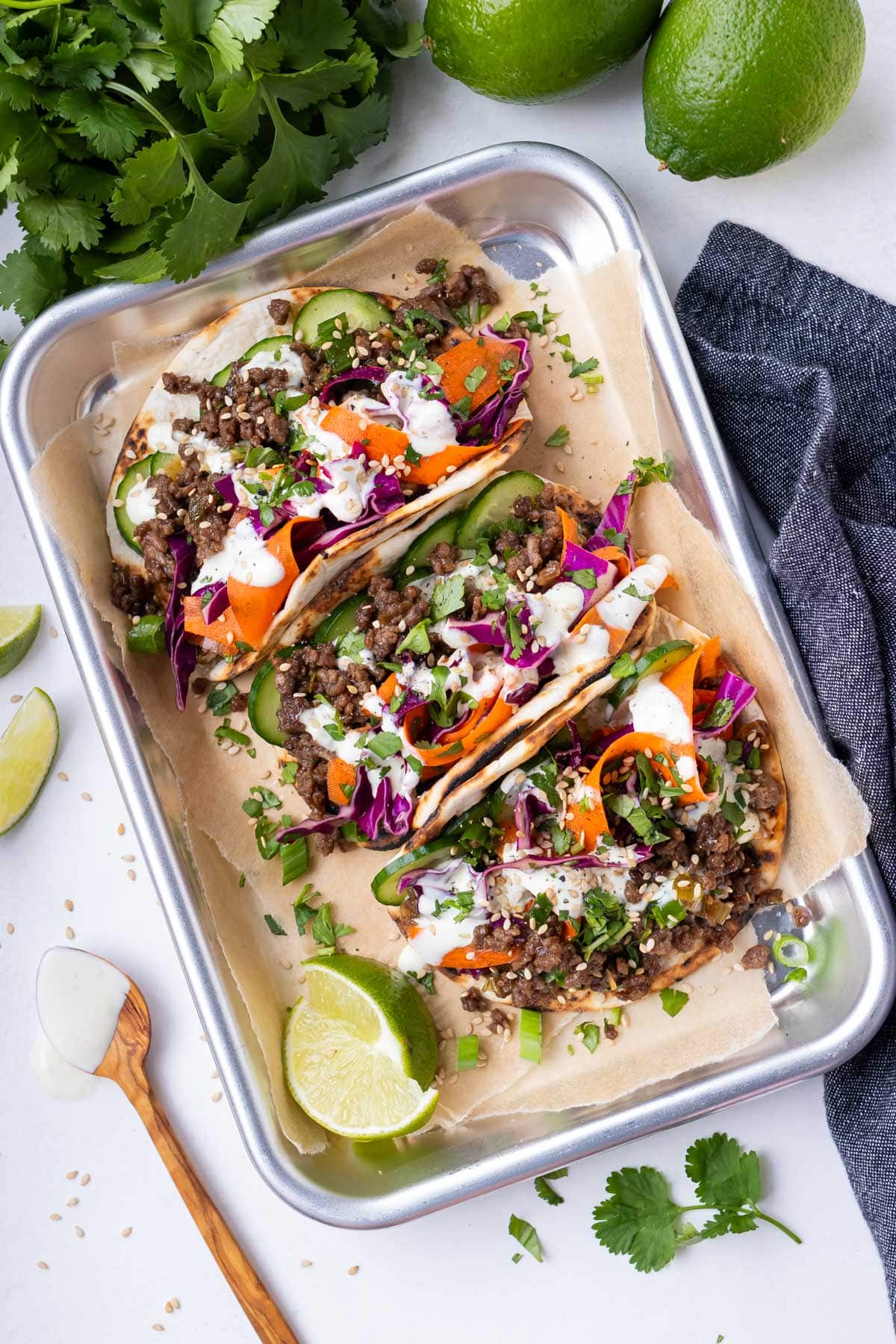 A tray full of Korean Beef Tacos is served for dinner with a sesame cabbage slaw and spicy wasabi mayo.