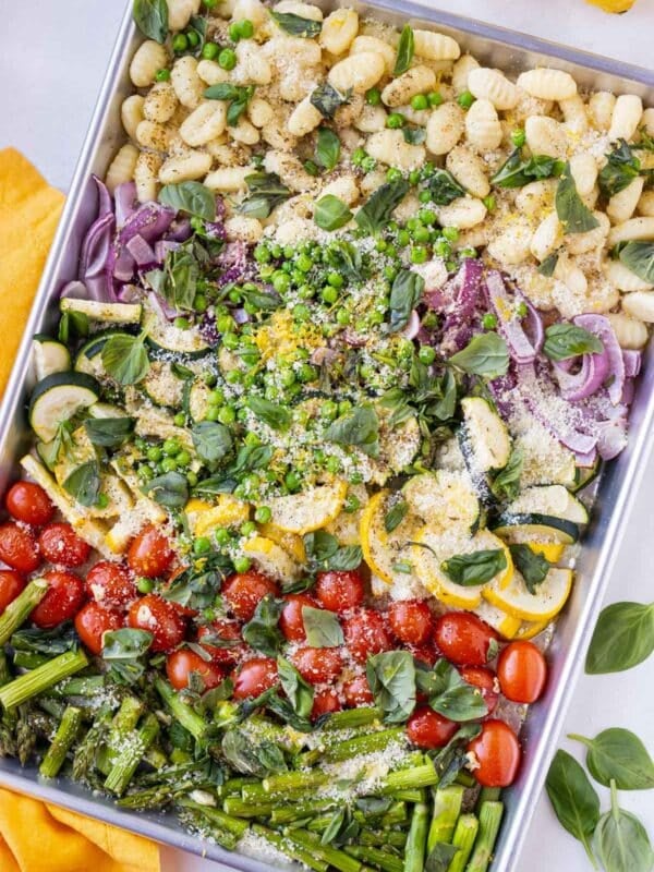 Sheet Pan Gnocchi Primavera after being roasted in the oven with vegetables, lemon juice, and fresh basil and tarragon.
