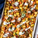 A sheet pan full of honey harissa chicken with garlick dill yogurt sauce.