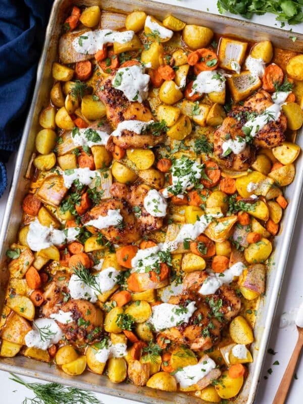 A sheet pan full of honey harissa chicken with garlick dill yogurt sauce.