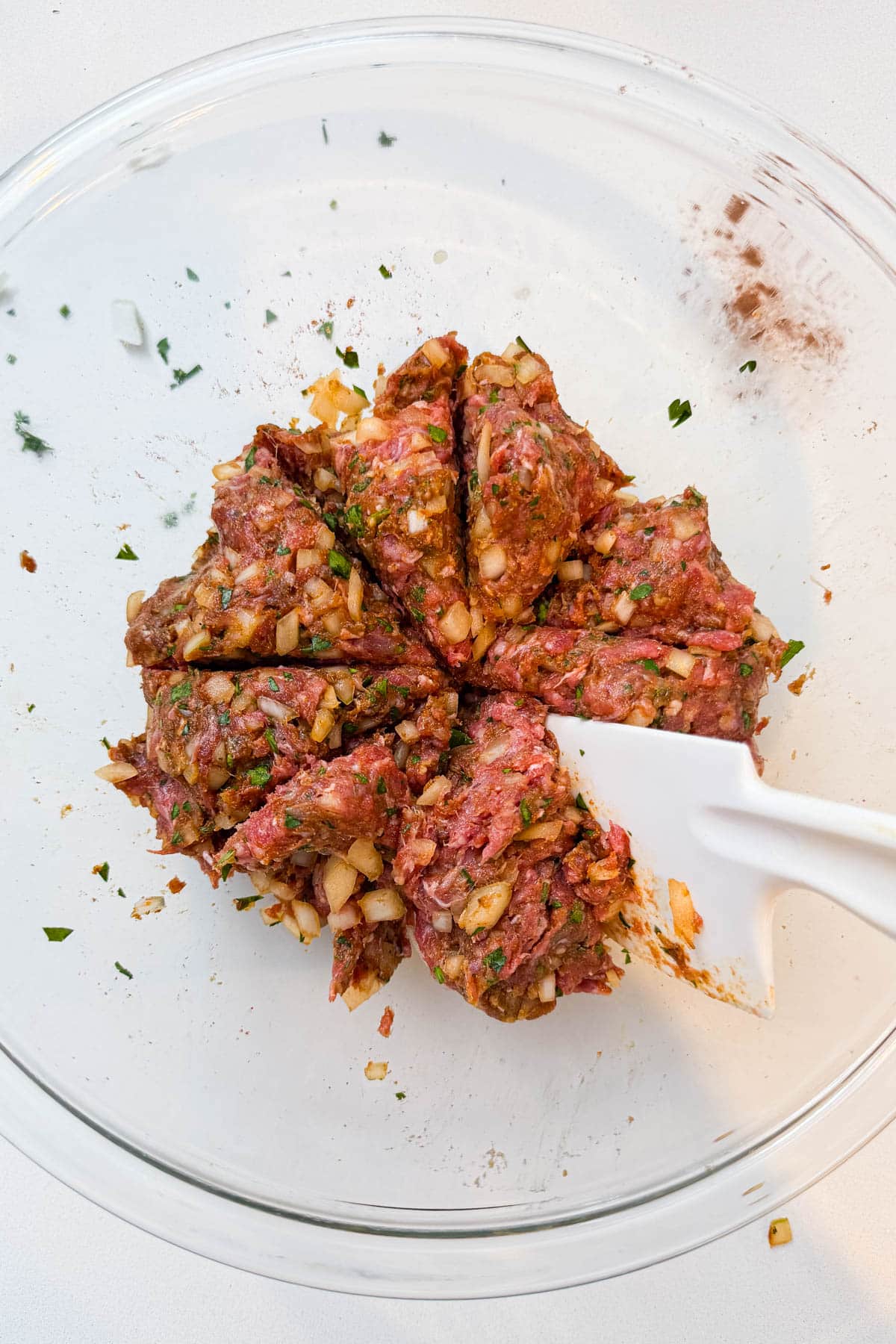 Seasoned ground beef mixture mixed and divided into 8 portions in a glass mixing bowl for Arayes.