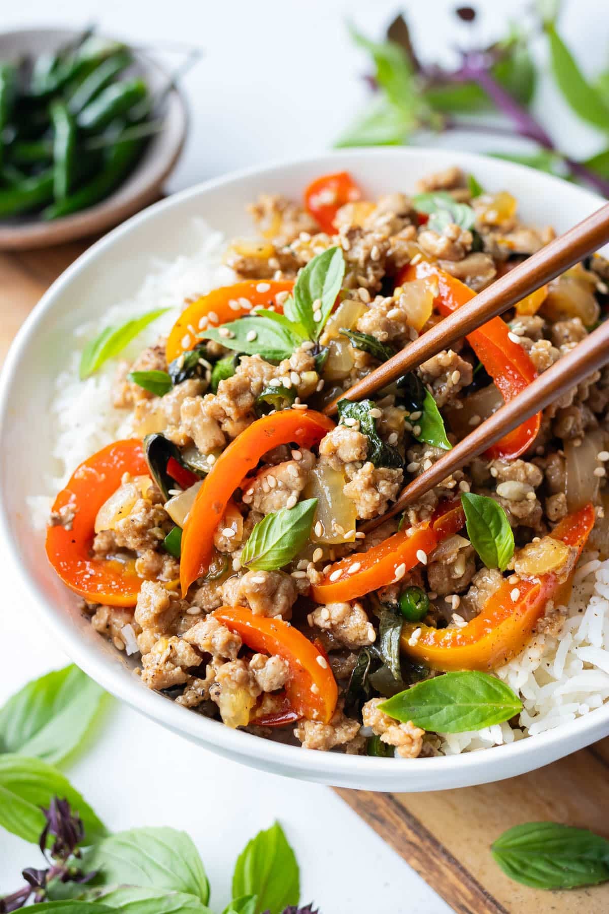 Thai Basil Ground Turkey Stir-Fry served over jasmine rice with chopsticks and fresh basil