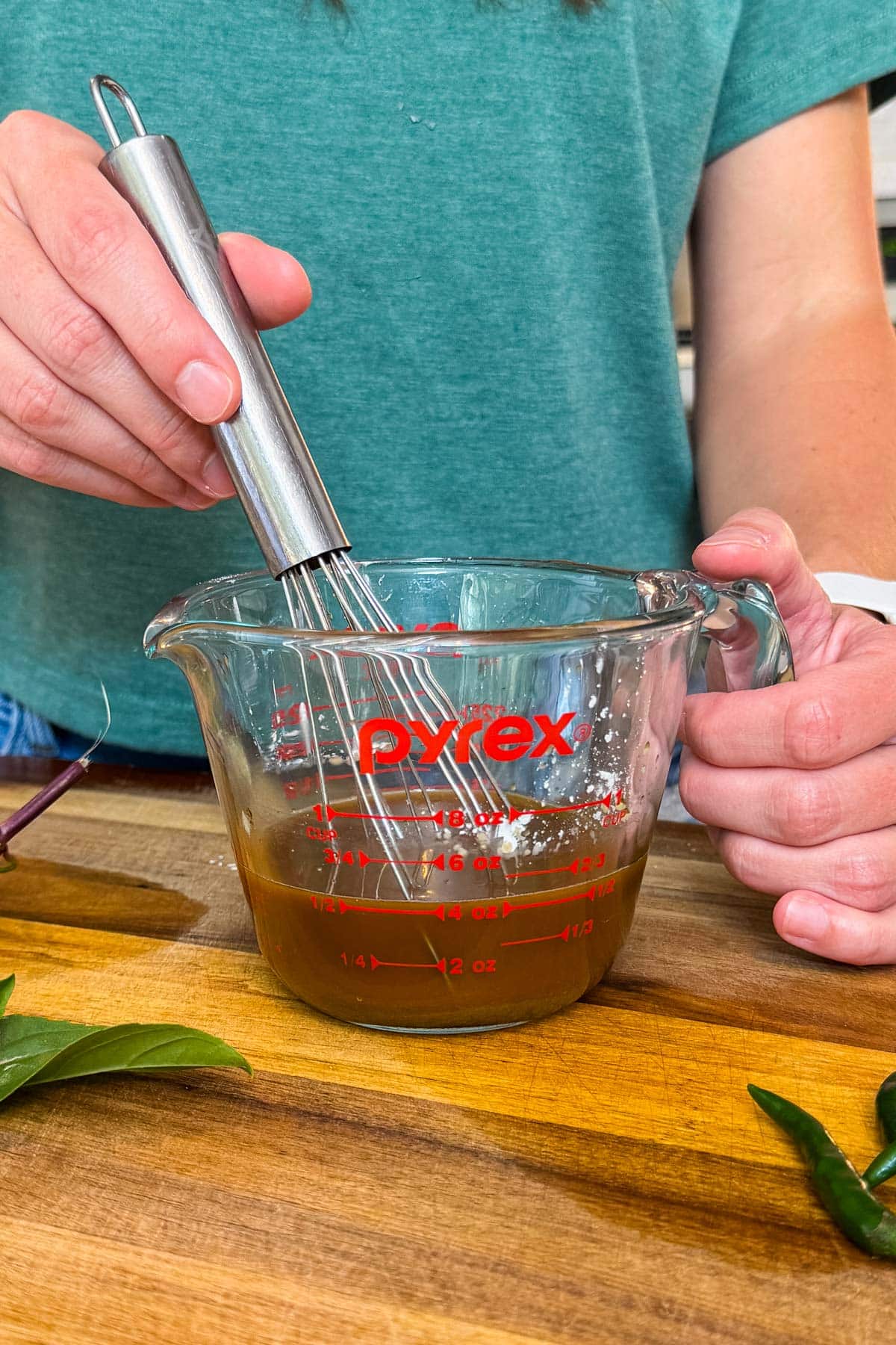 Whisking together the soy sauce, brown sugar, cornstarch, and fish sauce stir-fry sauce in a Pyrex measuring cup