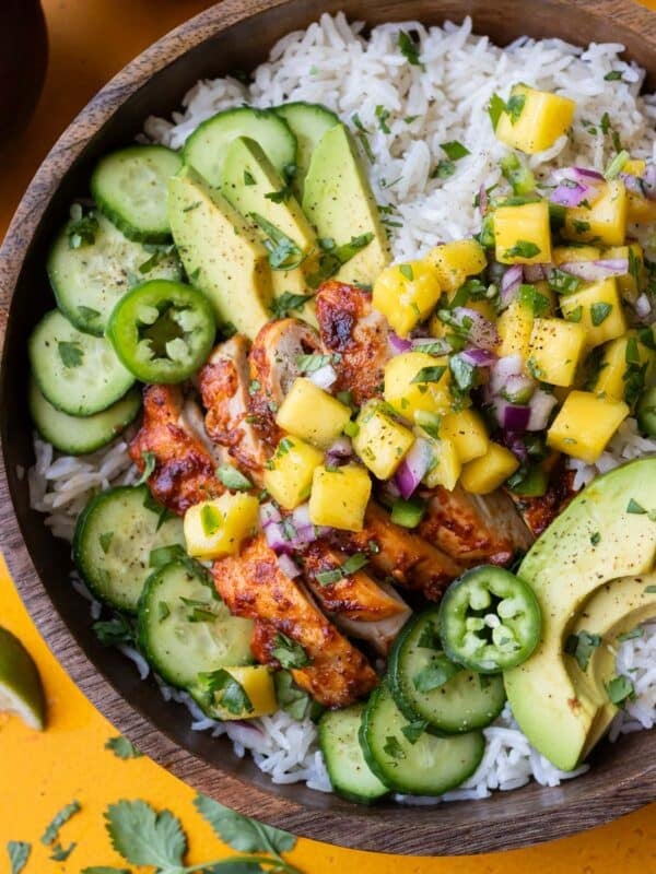 Chipotle mango chicken rice bowls with fresh mango salsa, cucumbers, and avocado.
