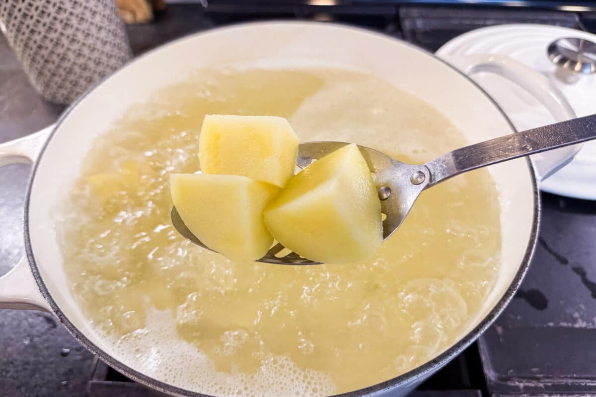 Tender boiled potato chunks ready to be drained.
