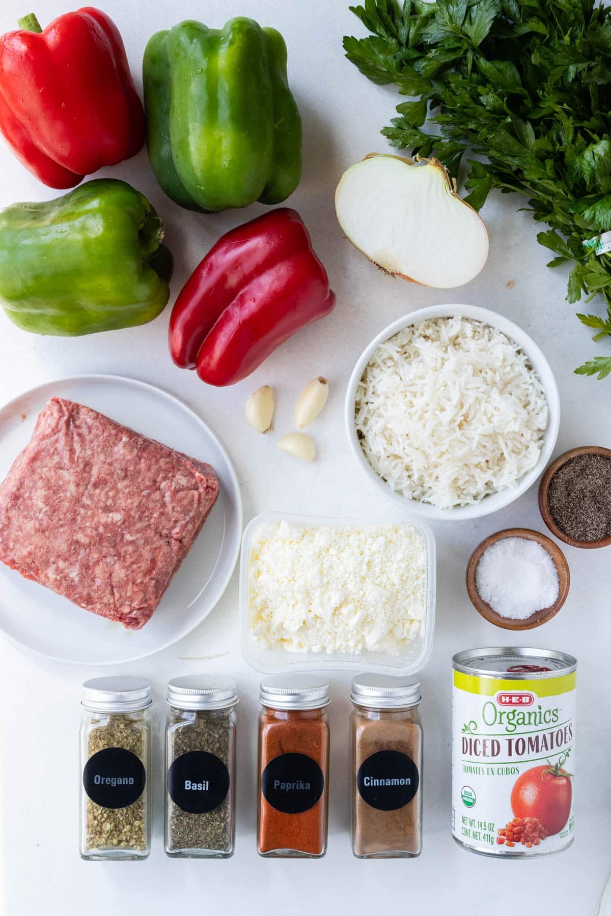 Bell peppers, cooked rice, ground beef, spices, diced tomatoes, and parsley are the ingredients for a Greek stuffed peppers recipe.