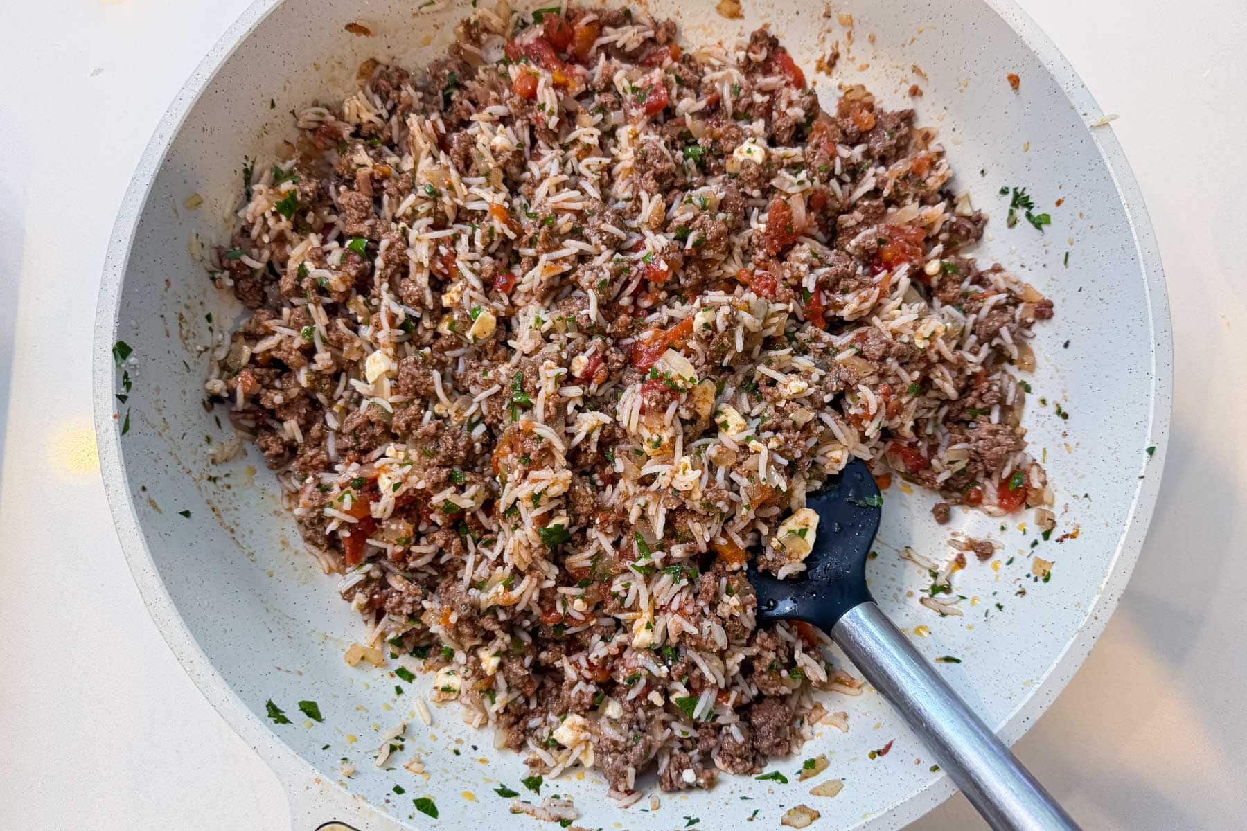 The beef and rice filling is mixed together for Greek stuffed peppers.