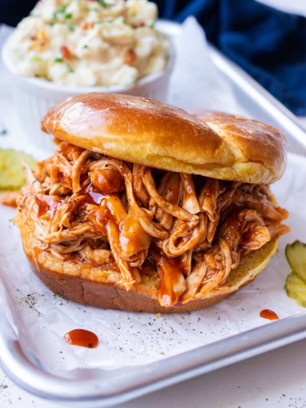 Slow cooker shredded BBQ chicken is served on a bun for an easy sandwich.