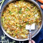 A low-carb and keto egg roll in a bowl recipe is being scooped out of a skillet with a spatula.