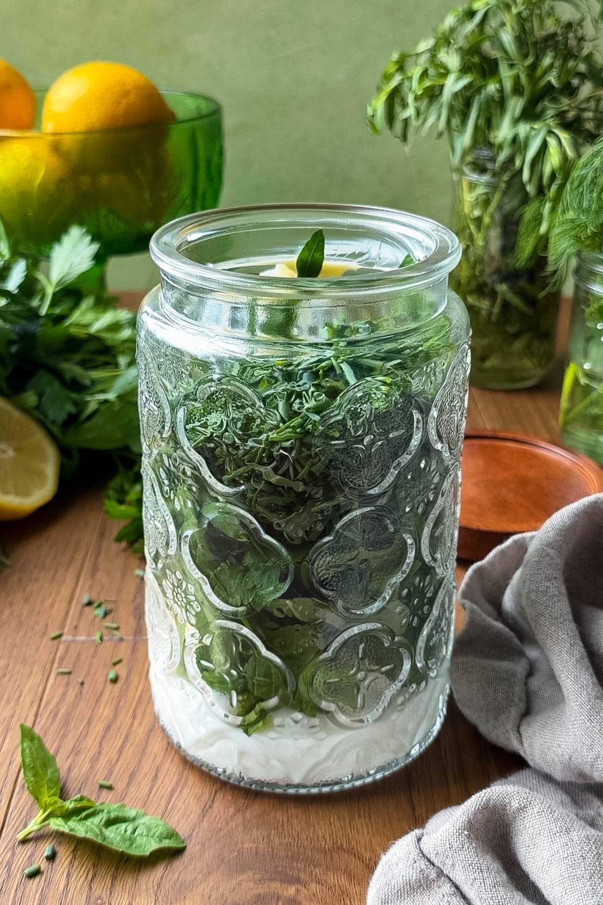 Greek yogurt, mayonnaise, fresh herbs, dijon, and worcestershire sauce are in a jar before blending into a creamy green goddess dressing.