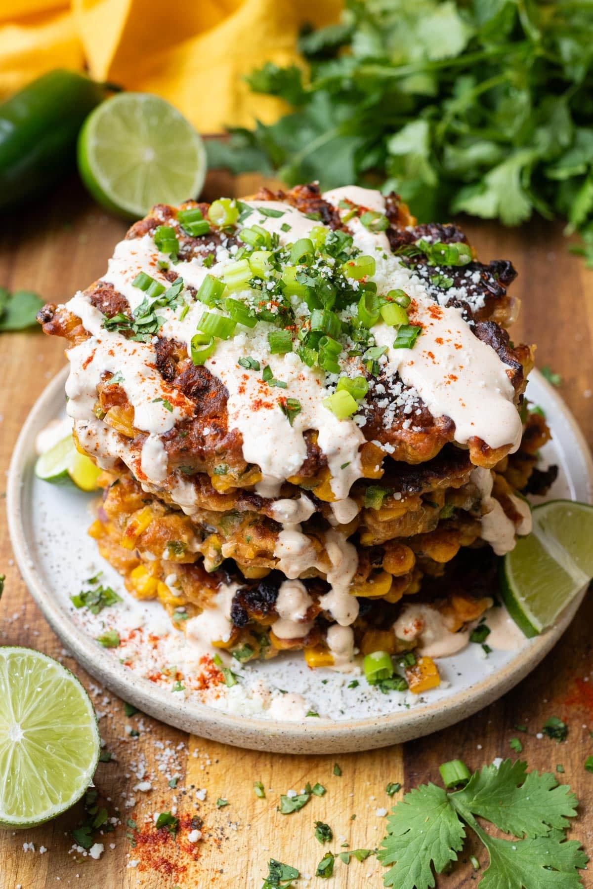 Elote corn fritters are served with cotija cheese, lime juice, and cilantro for an easy weeknight dinner.