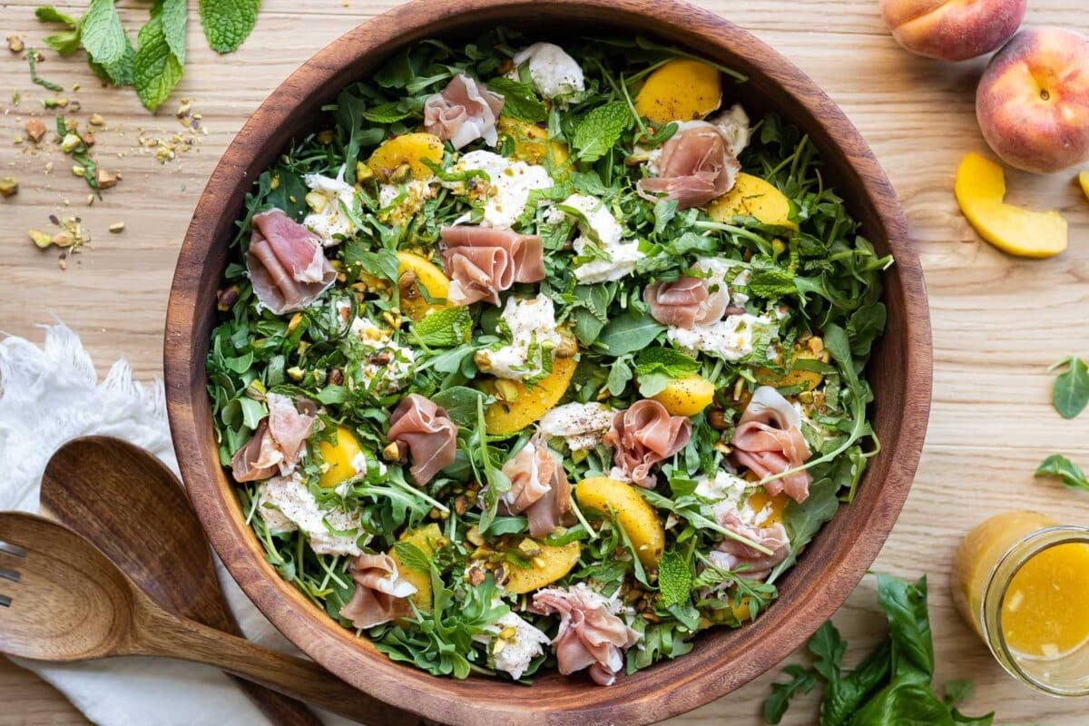 Prosciutto, burrata, peaches, pistachios, basil and mint over an arugula salad.